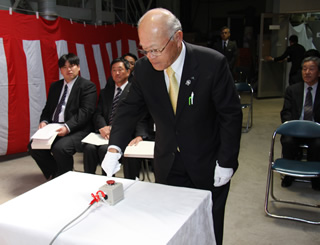 [写真] 起動のスイッチを押す石田正組合長