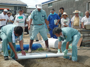 土壌消毒の実演を見学する参加者