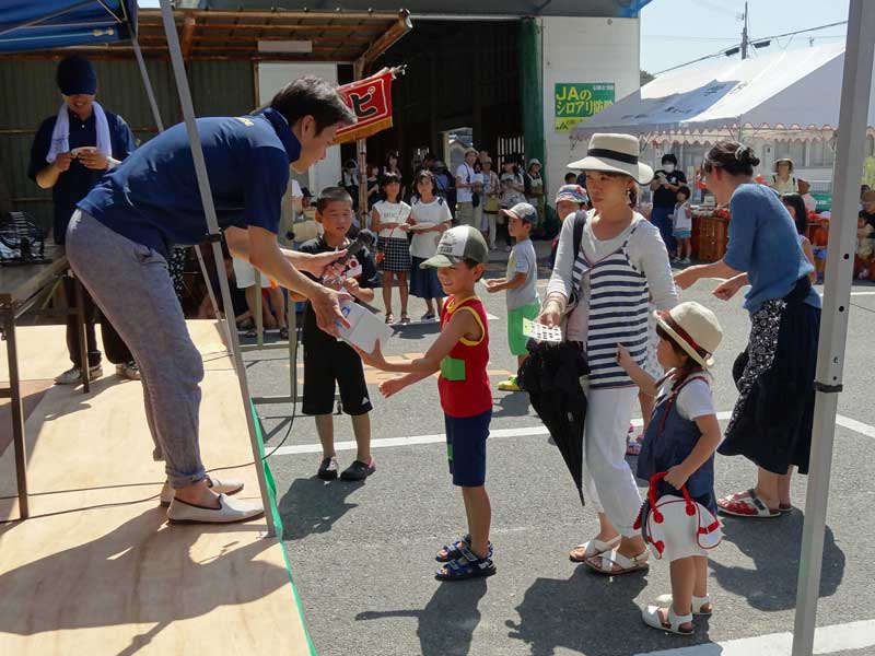 2016年8月のトピックス「ビンゴ大会で賞品を受け取る当選者（東浦淡路支店）」