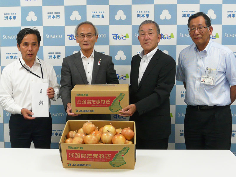 2018年6月のトピックス「洲本市役所での贈呈式(左から本條滋人教育長、竹内通弘市長、方城芳昭専務、上谷芳生経済部長)」
