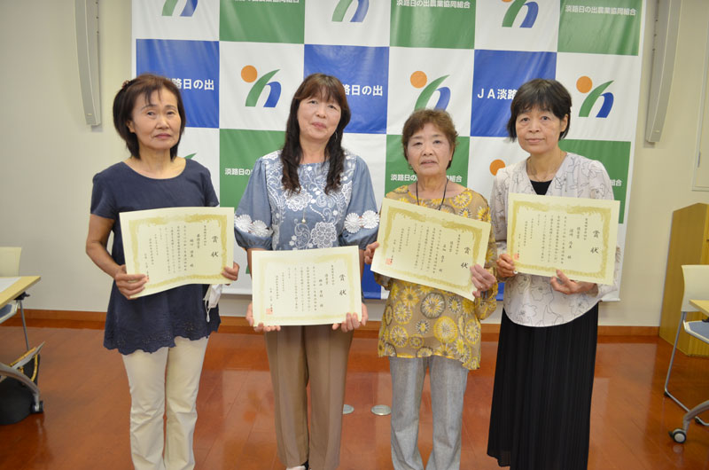 2021年7月のトピックス「表彰を持つ受賞者（左から樋口さん、横山さん、若畑さん、濵﨑さん）」